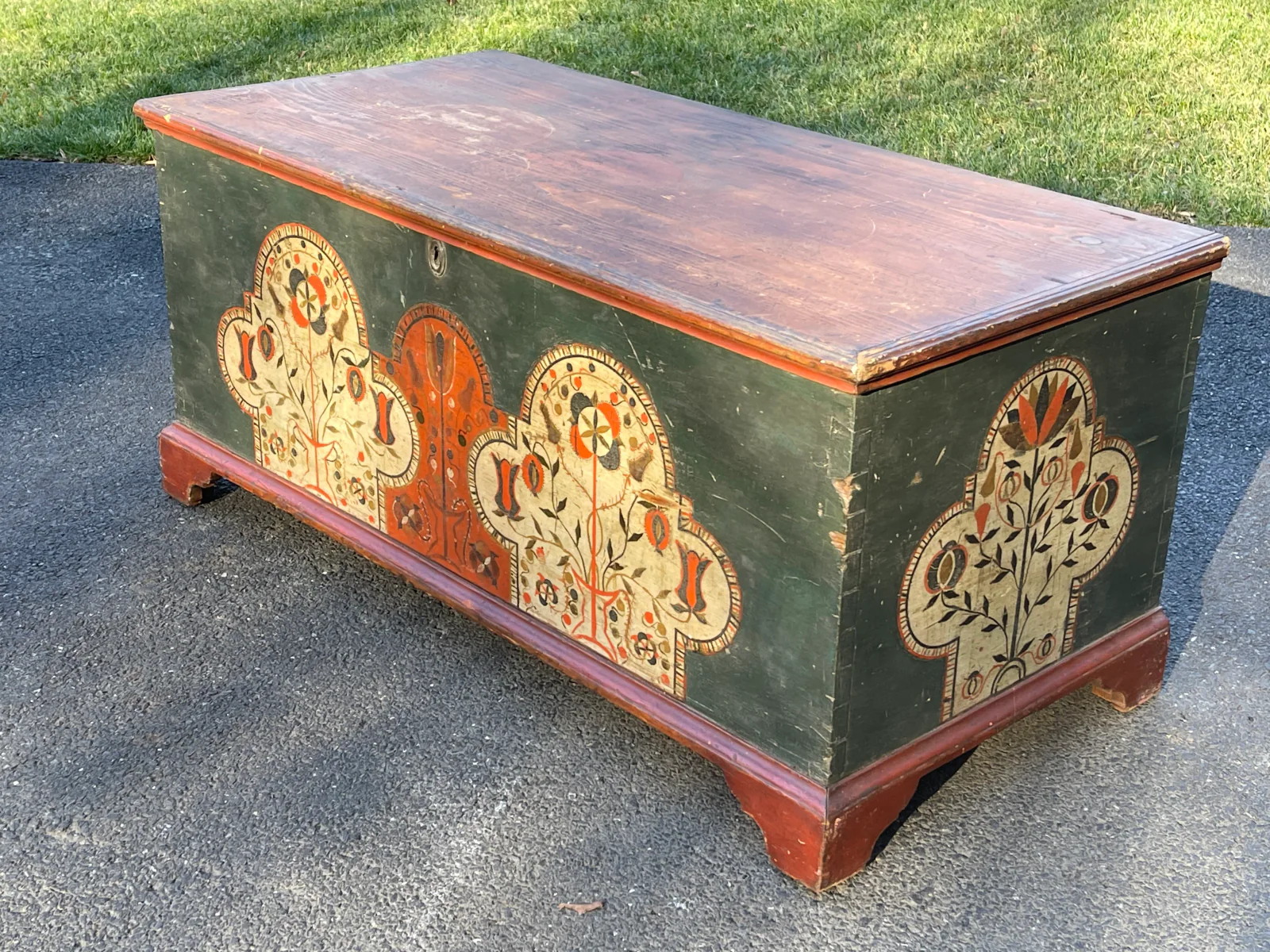 Green painted Pennsylvania German chest with floral panels and a red-and-orange painted trim