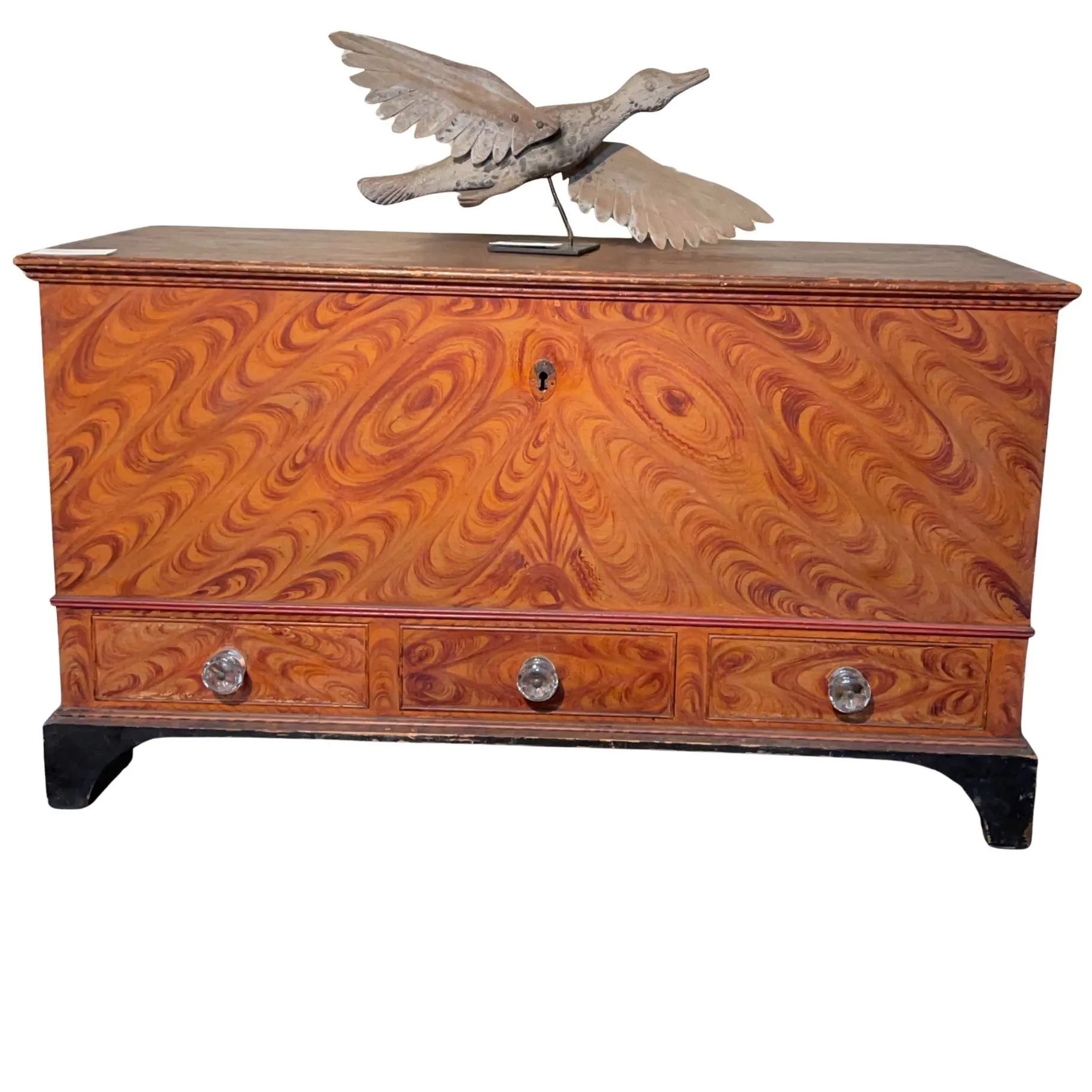 Fancy grain painted chest with decorated front, drawers, and original surface, isolated on a warm salmon background